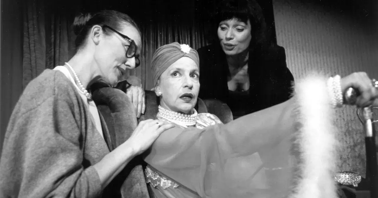 Marlena Milwiw młoda, w turbanie i perłach, z dwiema kobietami u boku, w teatralnej scenie.