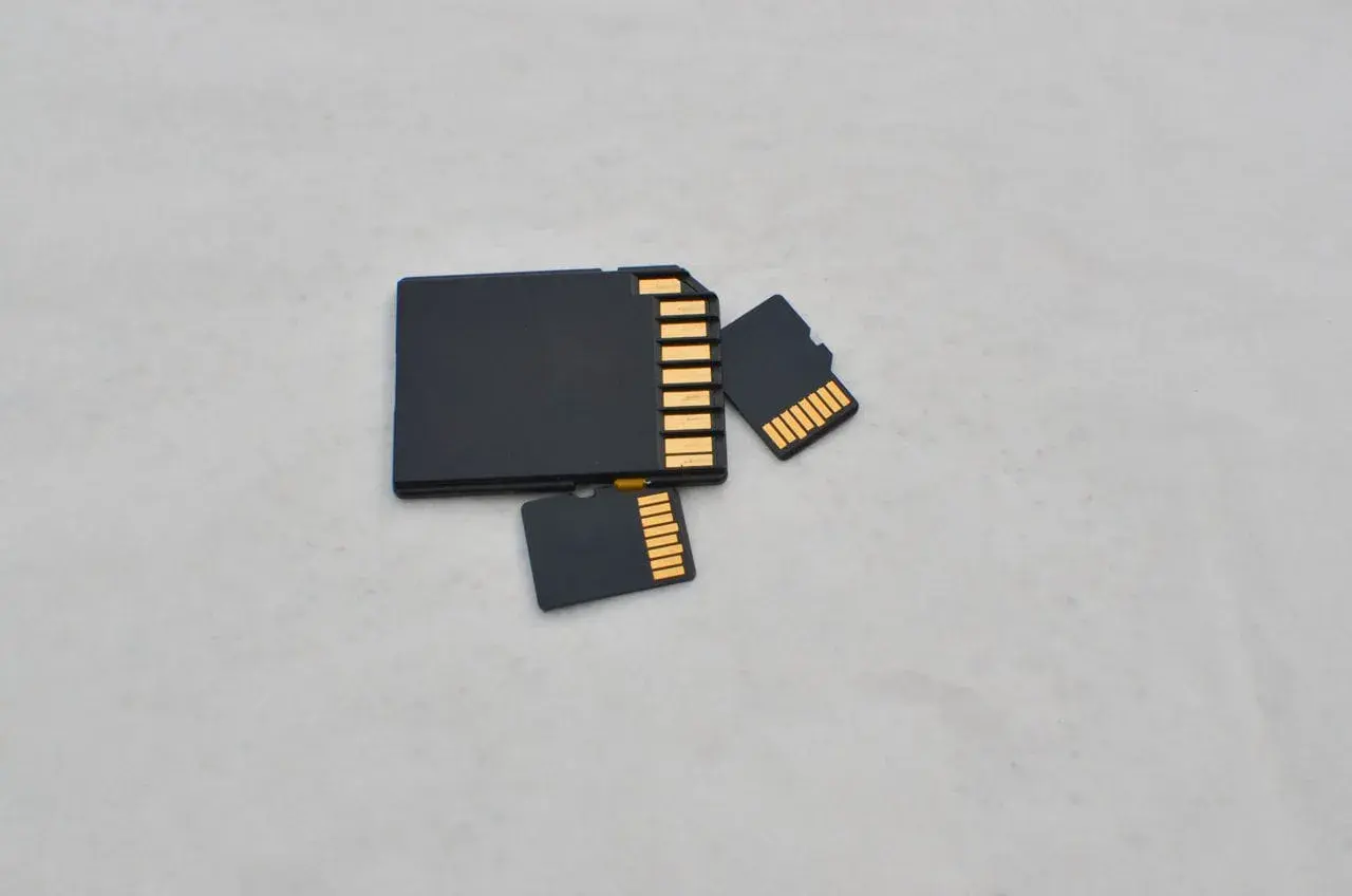 Porównanie rozmiarów: duża karta SD i dwie mniejsze karty microSD (TF). Różnica w wielkości jest oczywista.