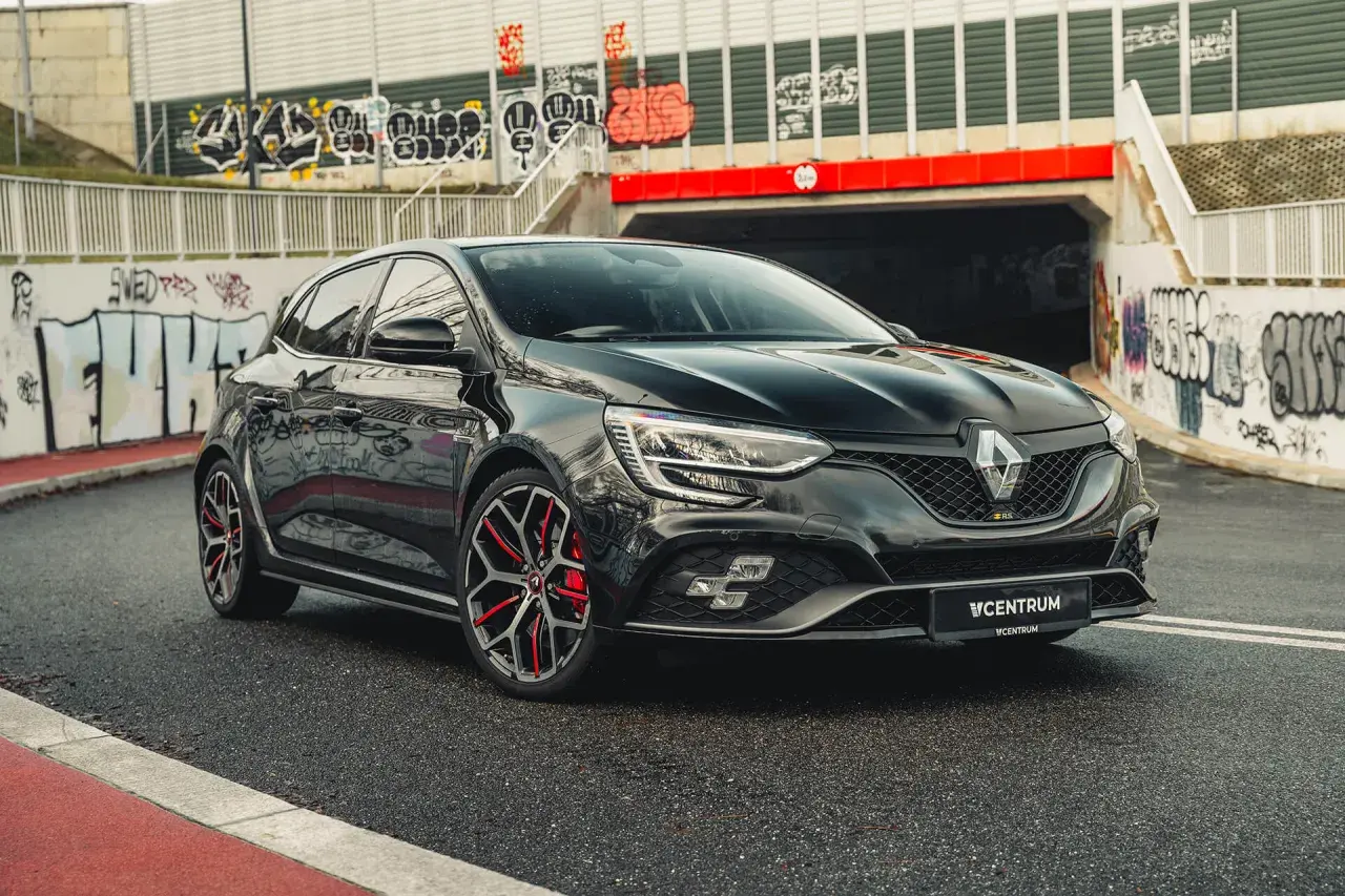 Czarny Renault Megane RS na tle graffiti. Idealny wybór dla tych, którzy szukają sportowych emocji i atrakcyjnego **leasingu Renault Megane**.