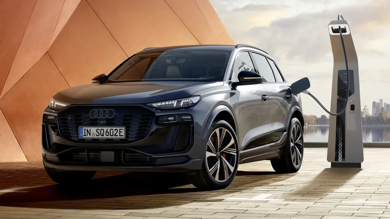 Elegancki Audi SQ6 z wtyczką ładowania podłączoną do stacji. Nowoczesny design i ekologiczna energia.