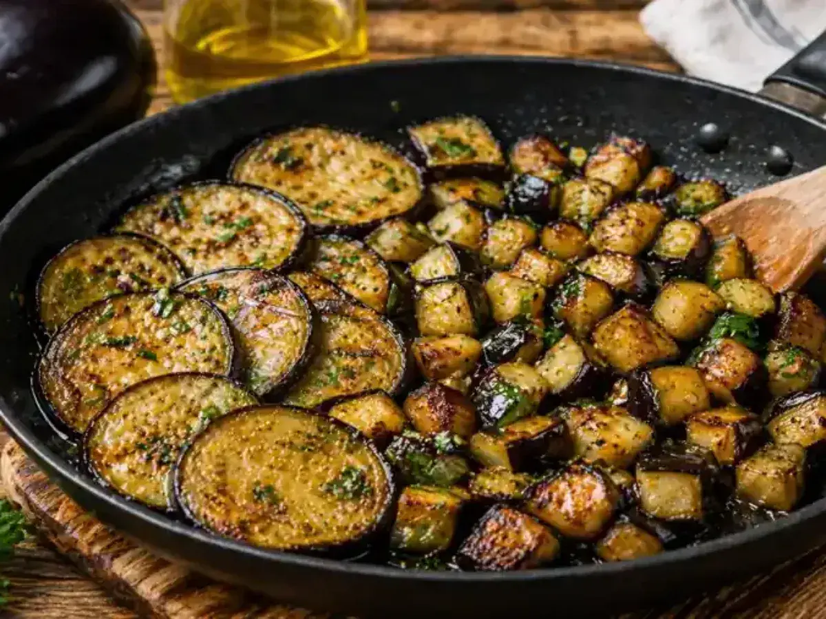 Aubergines coupées en rondelles et en dés, poêlées avec des herbes. Une délicieuse recette aubergine poêle prête à être dégustée.