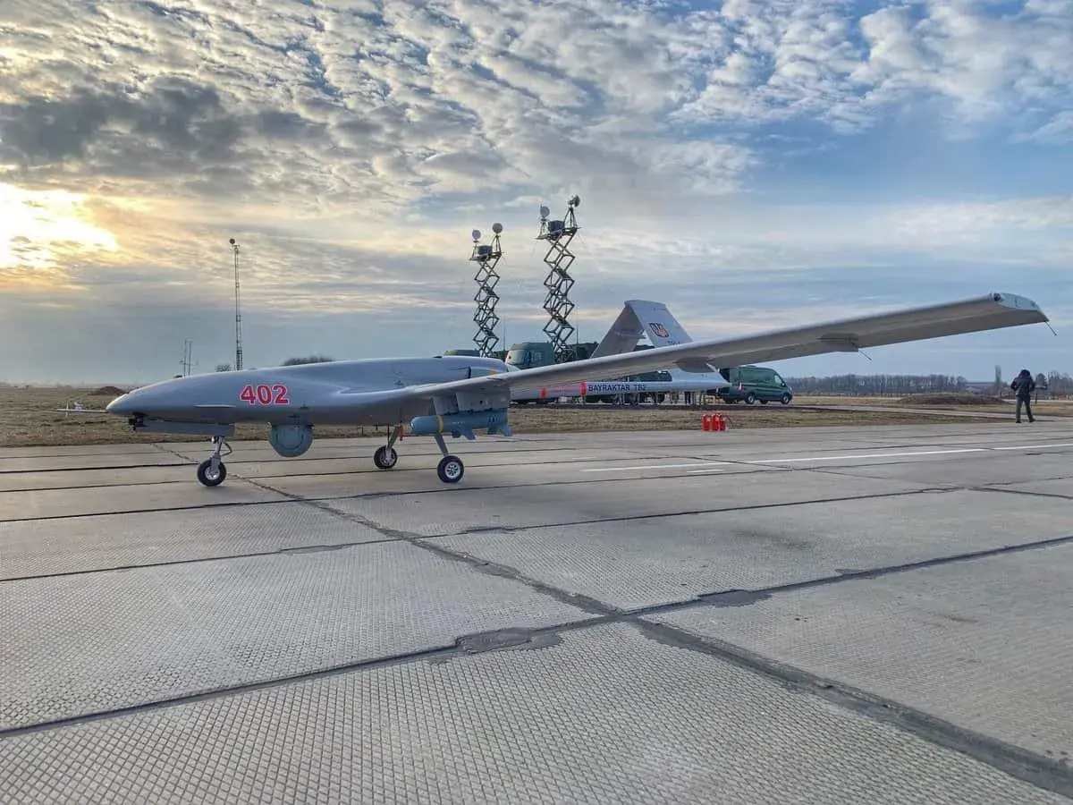 Szary dron Bayraktar TB-2 z numerem 402 na płycie lotniska, gotowy do akcji.