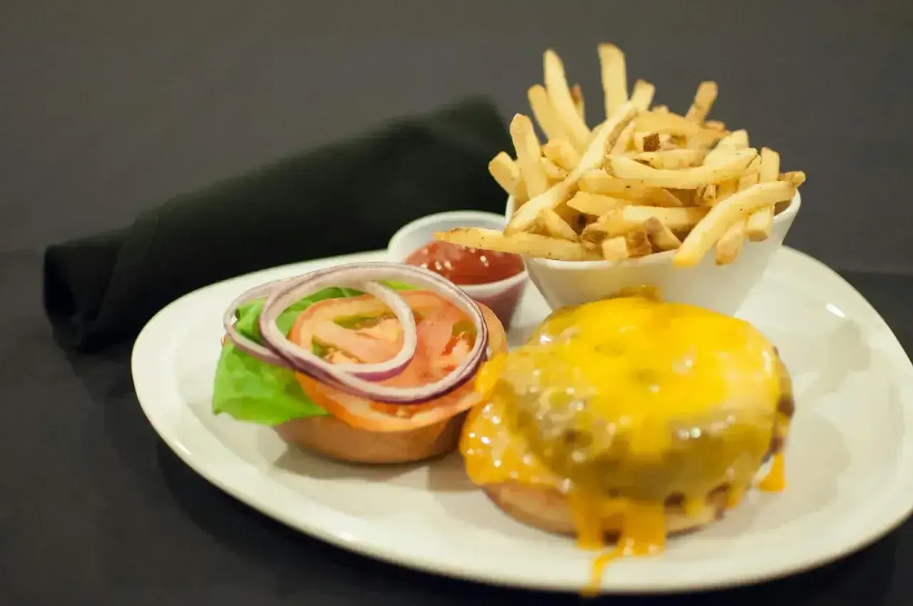 Pyszny burger z serem, frytki i ketchup. Czym się różni hamburger od burgera? Ten wygląda na pyszny!