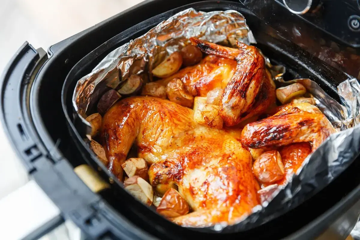 Pollo dorato e patate croccanti in friggitrice ad aria, un pasto delizioso pronto in poco tempo.