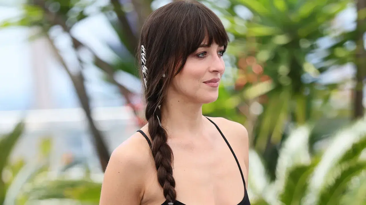 Mujer con flequillo y una trenza lateral adornada con accesorios plateados, luciendo unas trenzas de moda.