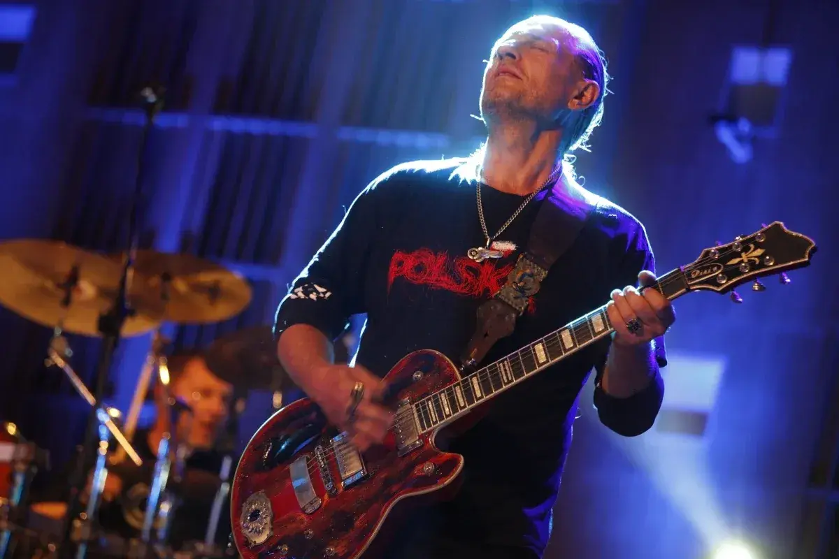 Andrzej Nowak z TSA gra na gitarze, zamykając oczy w transie.