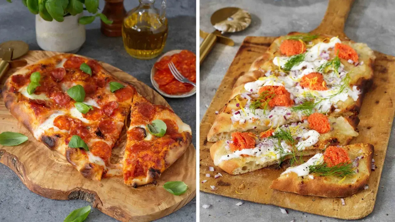 Två pizzor på träskärbrädor. En med pepperoni och basilika, den andra med gräddfil, rödlök, dill och rom. Båda ser ut att ha en härlig pizza sås.