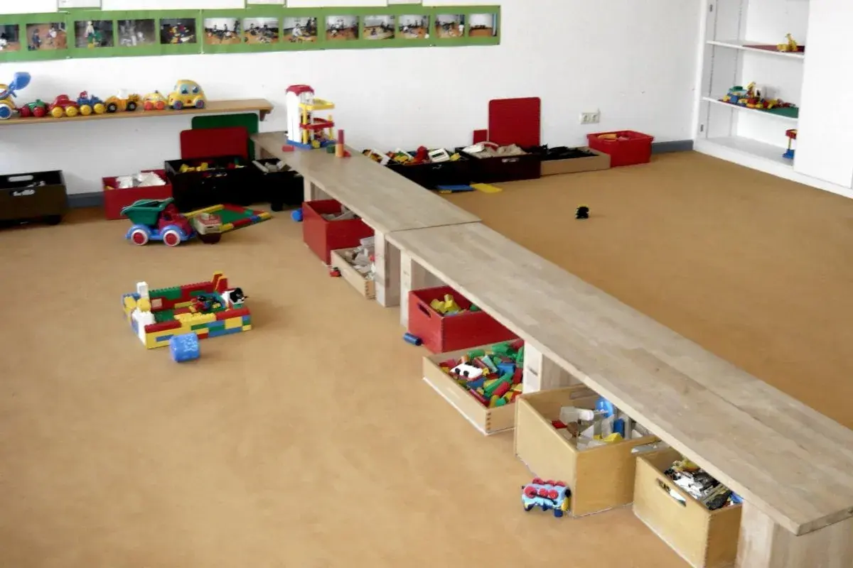 Spielzeugkisten und Bausteine im Kita-Raum laden zu kreativen Ideen ein.