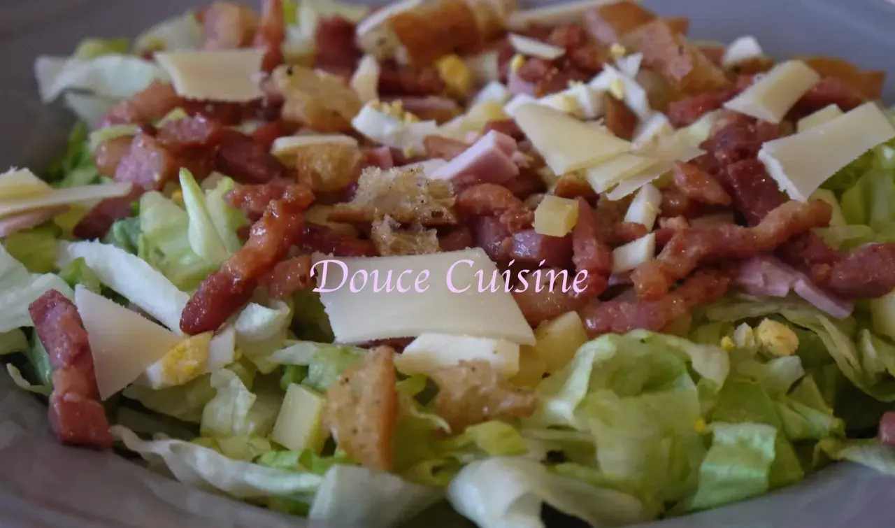 Salade savoyarde généreuse avec lardons, fromage, œuf dur et croûtons. Un délice pour les papilles.