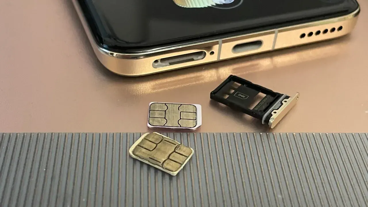 Dwie karty SIM i tacka na karty obok telefonu. Czy można mieć dwie karty SIM z tym samym numerem? To pytanie nurtuje wielu użytkowników.