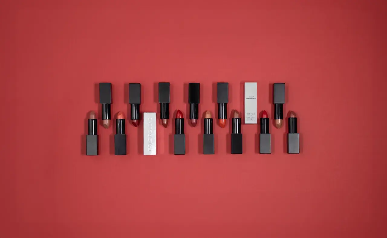 Une collection de rouges à lèvres aux teintes variées, dont un rouge rose éclatant, sur fond rouge.