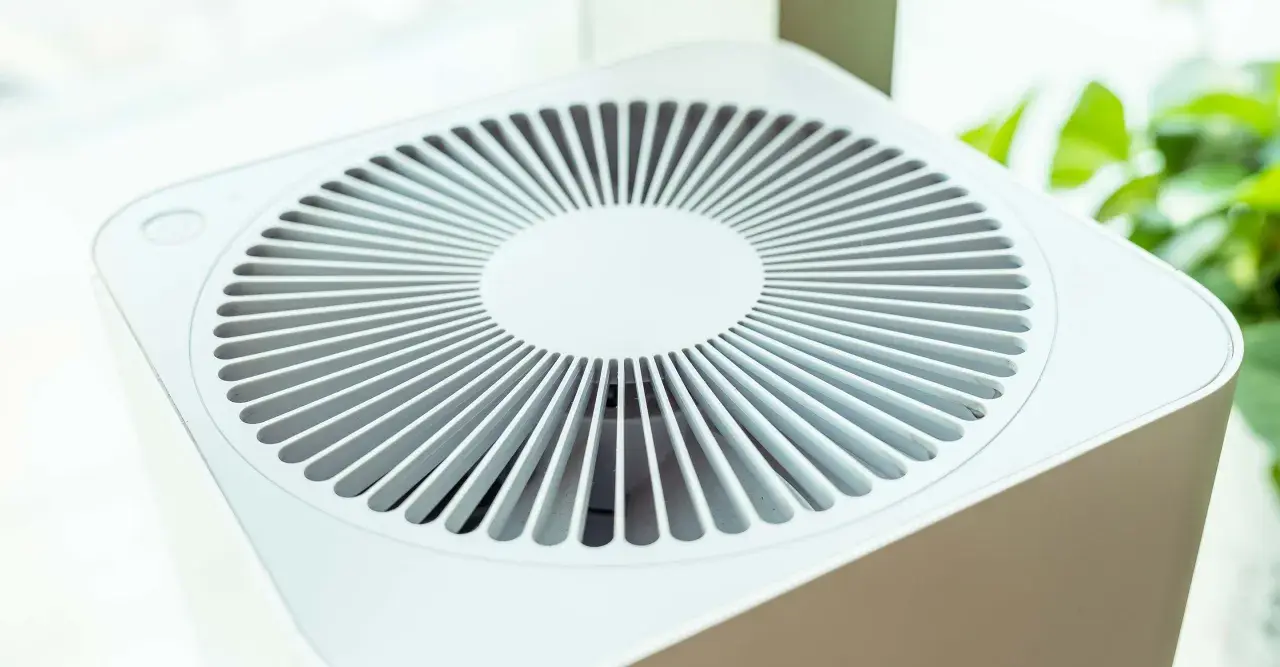 Purificador de aire blanco con rejilla circular. Considera las contraindicaciones del purificador de aire para un uso seguro y efectivo.