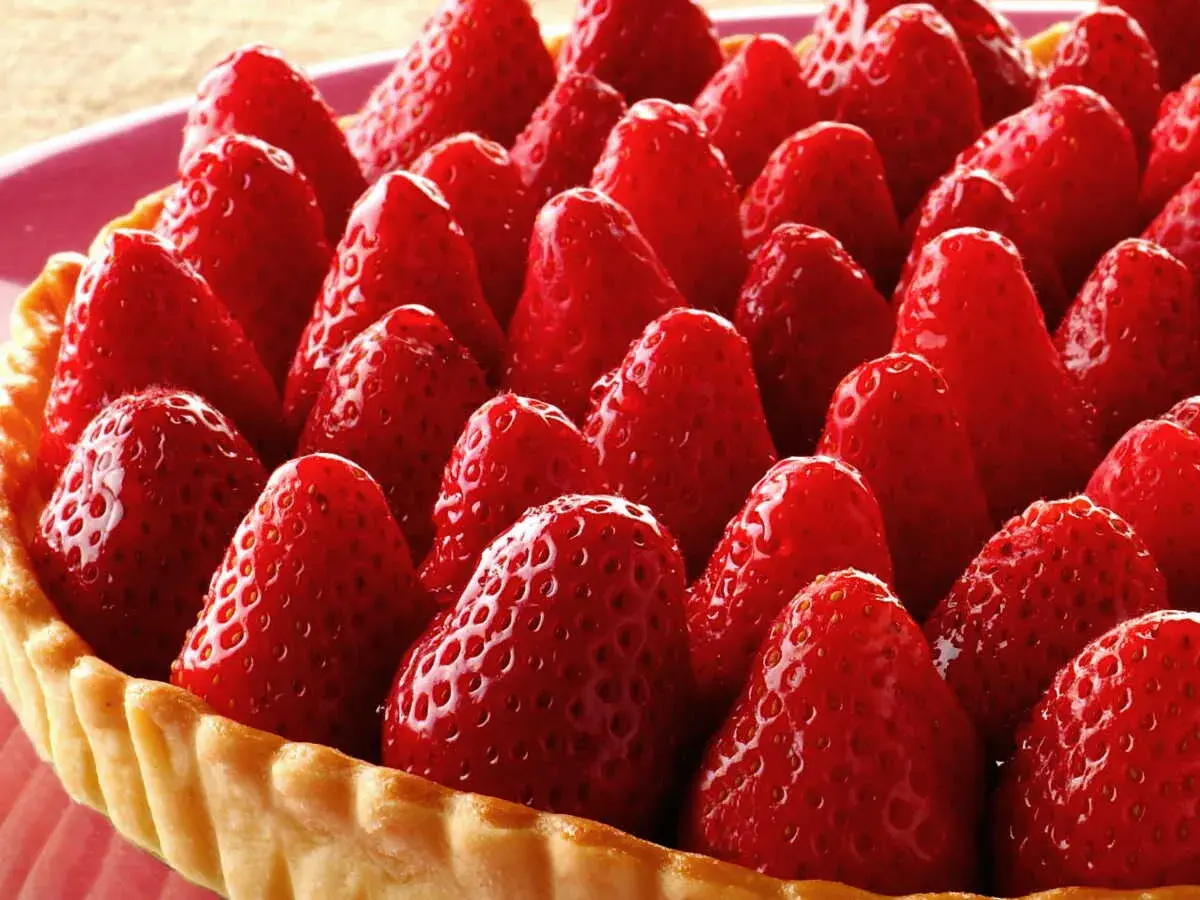 Tarte aux fraises sans crème pâtissière, une explosion de fruits rouges sur une pâte dorée. Un délice simple et fruité.