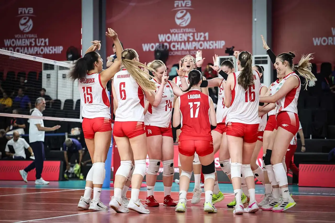Drużyna siatkówki kobiet u21 świętuje zwycięstwo na Mistrzostwach Świata. Radość i entuzjazm po wygranej.