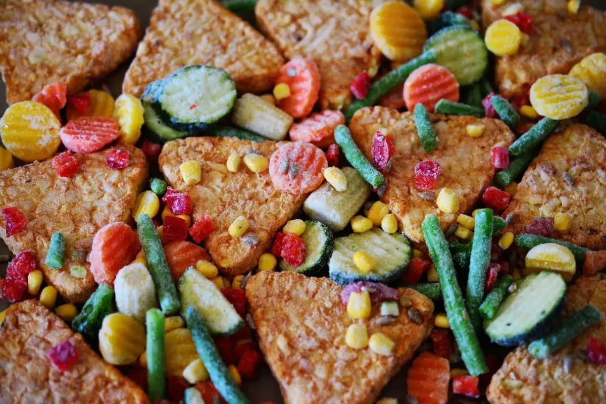 Un mix di cibi processati: patate fritte, carote, piselli, mais, zucchine e fagiolini. Un esempio di cosa sono i cibi processati.