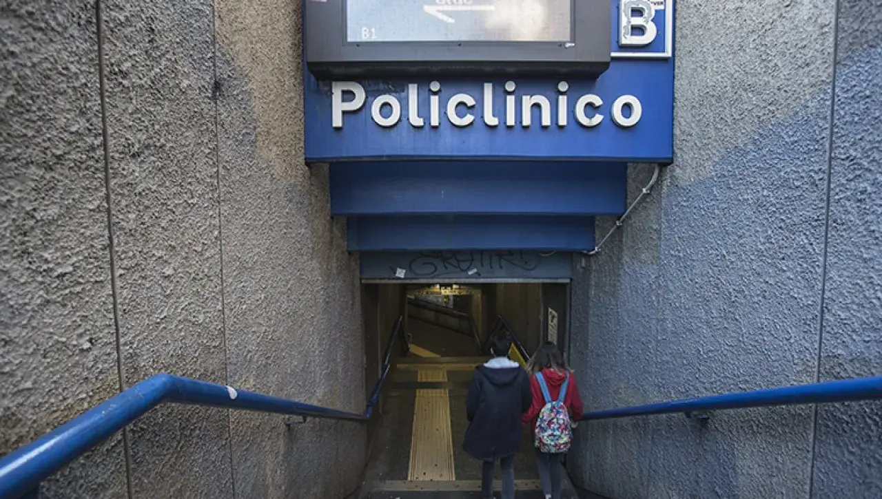 Due persone scendono le scale verso l'ingresso della stazione policlinico metro B.
