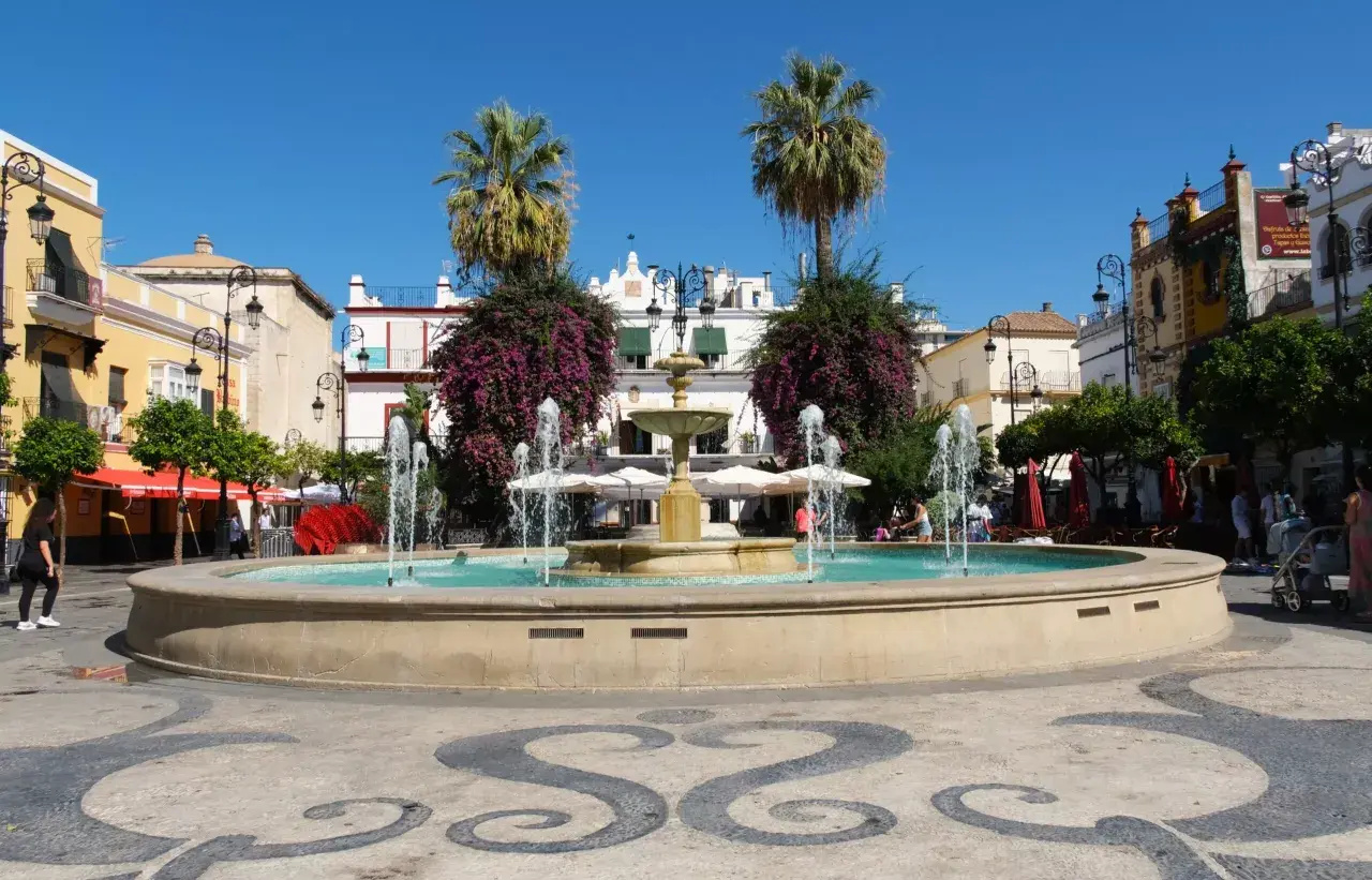Plaza con fuente y palmeras. Un buen punto de partida para saber cómo llegar a Sanlúcar de Barrameda.