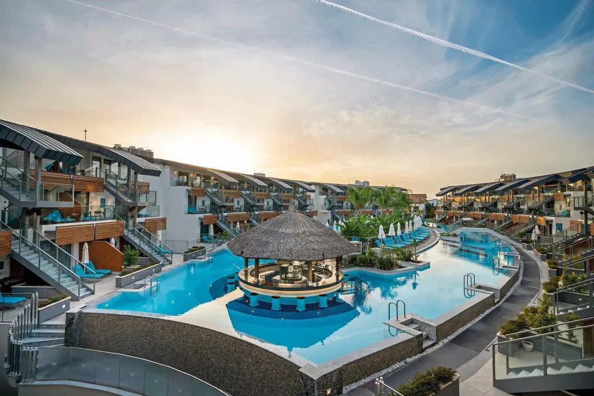 Ein luxuriöser Poolbereich mit Swim-up-Bar im Liberty Fabay, umgeben von modernen Hotelgebäuden und Palmen.