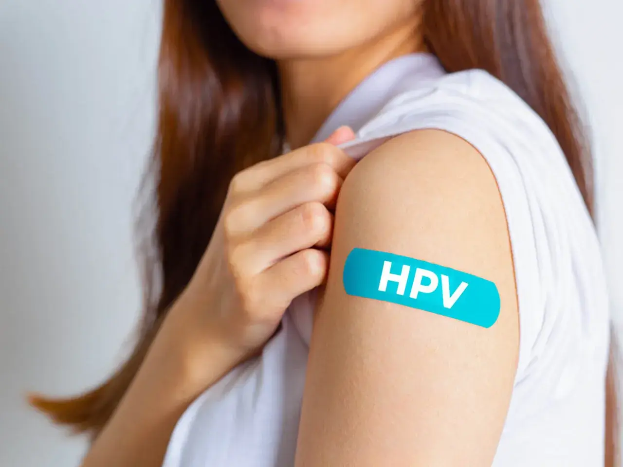 Ramię z plastrem z napisem HPV. Po szczepieniu mam HPV, co z seksem? Bezpieczeństwo przede wszystkim.