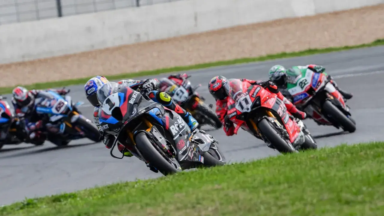 Pilotos de superbikes compiten en una carrera, inclinándose en una curva. ¡Emoción pura donde ver superbikes!