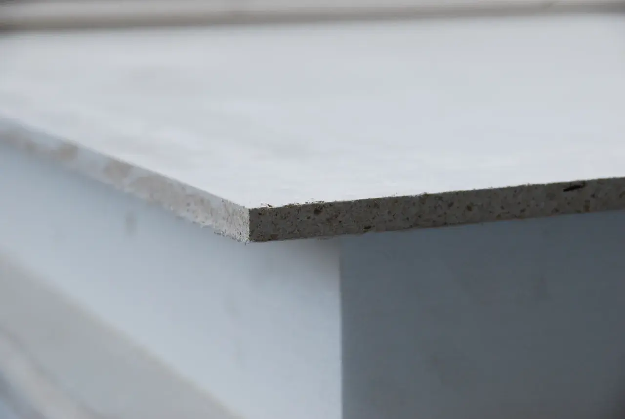 Szara płyta mgo, widoczna z boku, z widoczną teksturą materiału.
