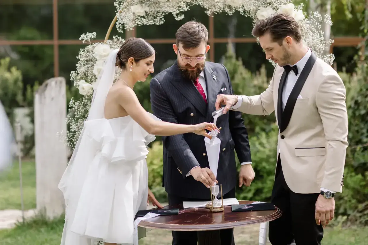 Para młoda i celebrans podczas ceremonii wsypywania piasku.
