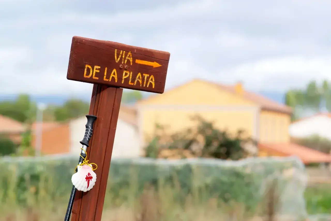 Drewniany drogowskaz Via de la Plata z muszlą pielgrzyma i laską.
