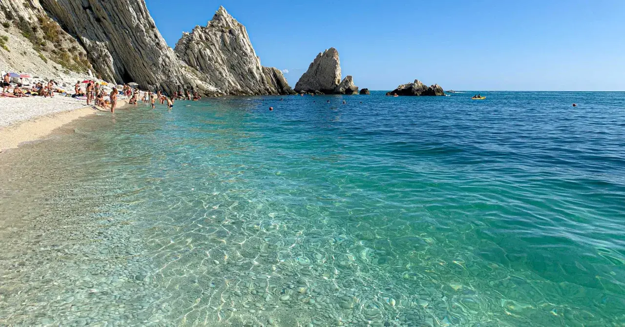 Spiaggia delle Due Sorelle: come arrivare a questo paradiso. Acque cristalline, scogliere imponenti e bagnanti che si godono il sole.