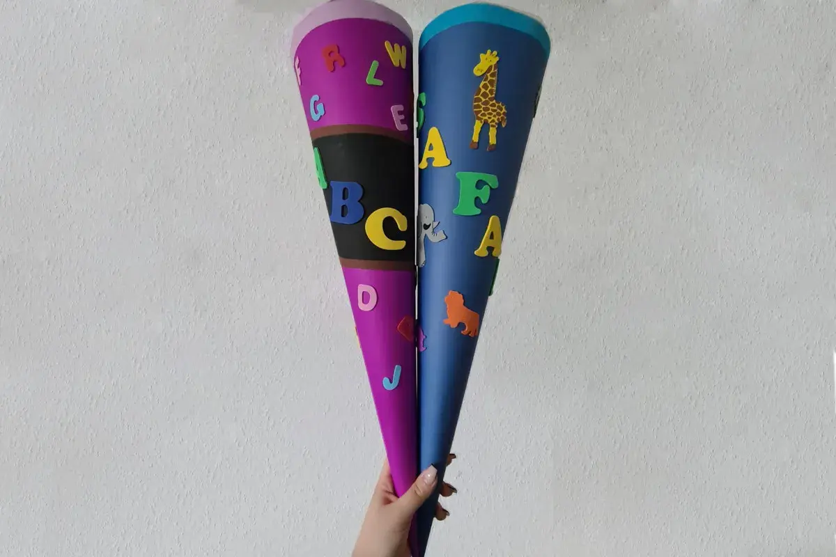 Zwei bunte Schultüten, liebevoll gestaltet mit Buchstaben und Tieren, sind bereit für den ersten Schultag. Ein tolles Ergebnis vom **Schultüte basteln**!