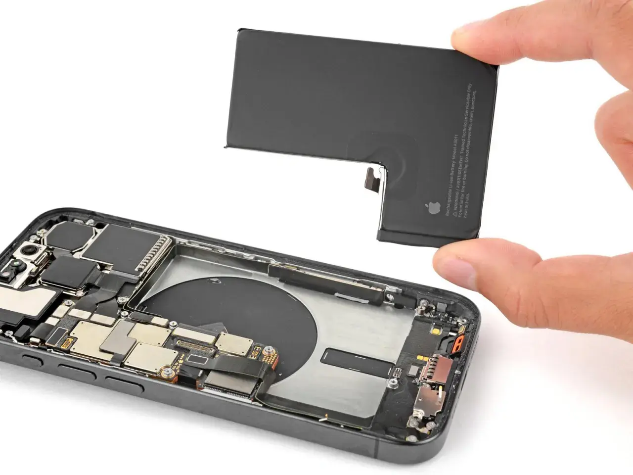Wymiana baterii w iPhone 16. Dłoń trzyma nową baterię, gotową do montażu w otwartym telefonie.