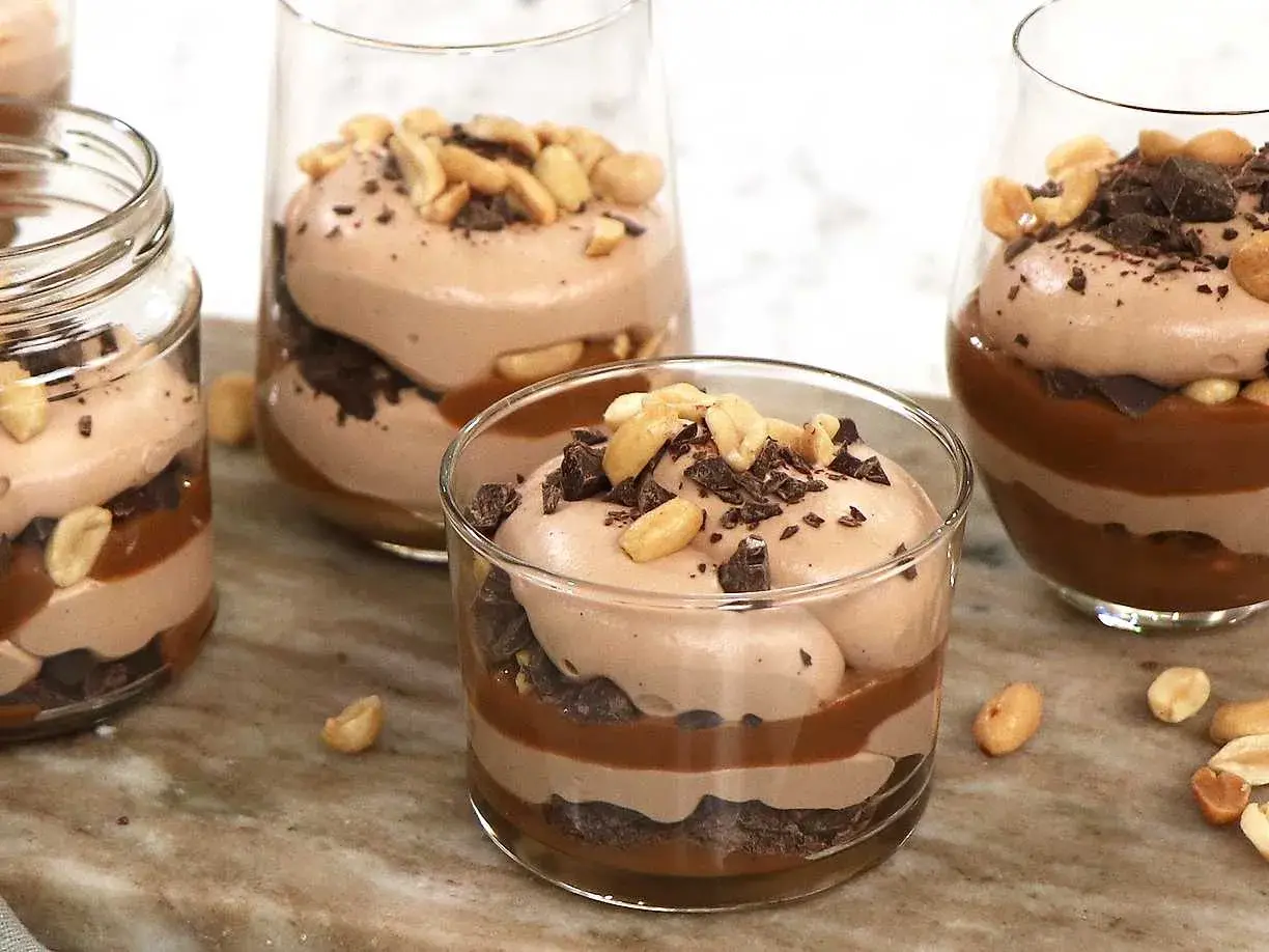 Chokladmousse-desserter i glas med lager av choklad, kolasås och jordnötter. En härlig rocky road-upplevelse!