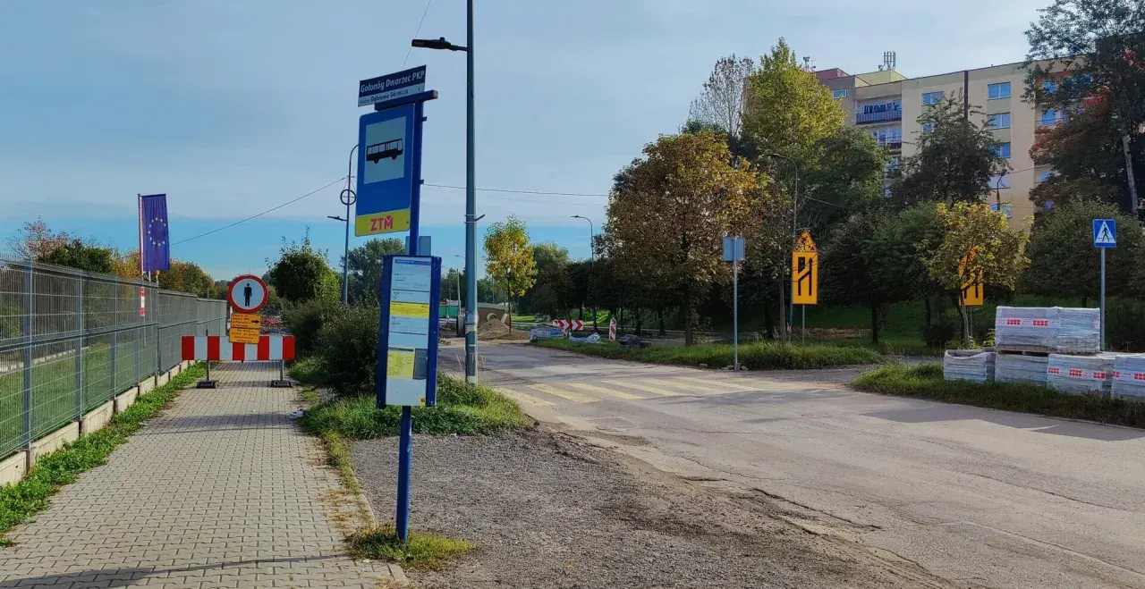 Przystanek autobusowy ZTM przy dworcu PKP w Grabownie Wielkim, z widocznym znakiem drogowym i pasami.
