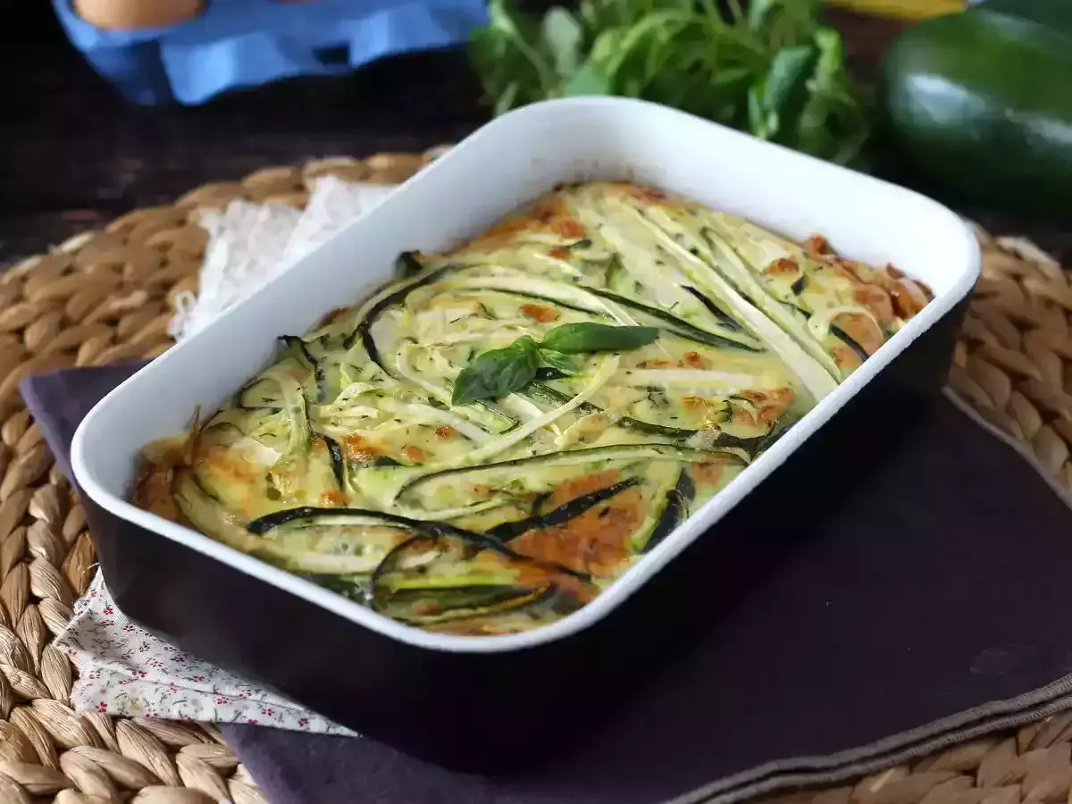 En gyllene frittata i ugn med tunna skivor zucchini och färska örter. En härlig rätt som doftar sommar.