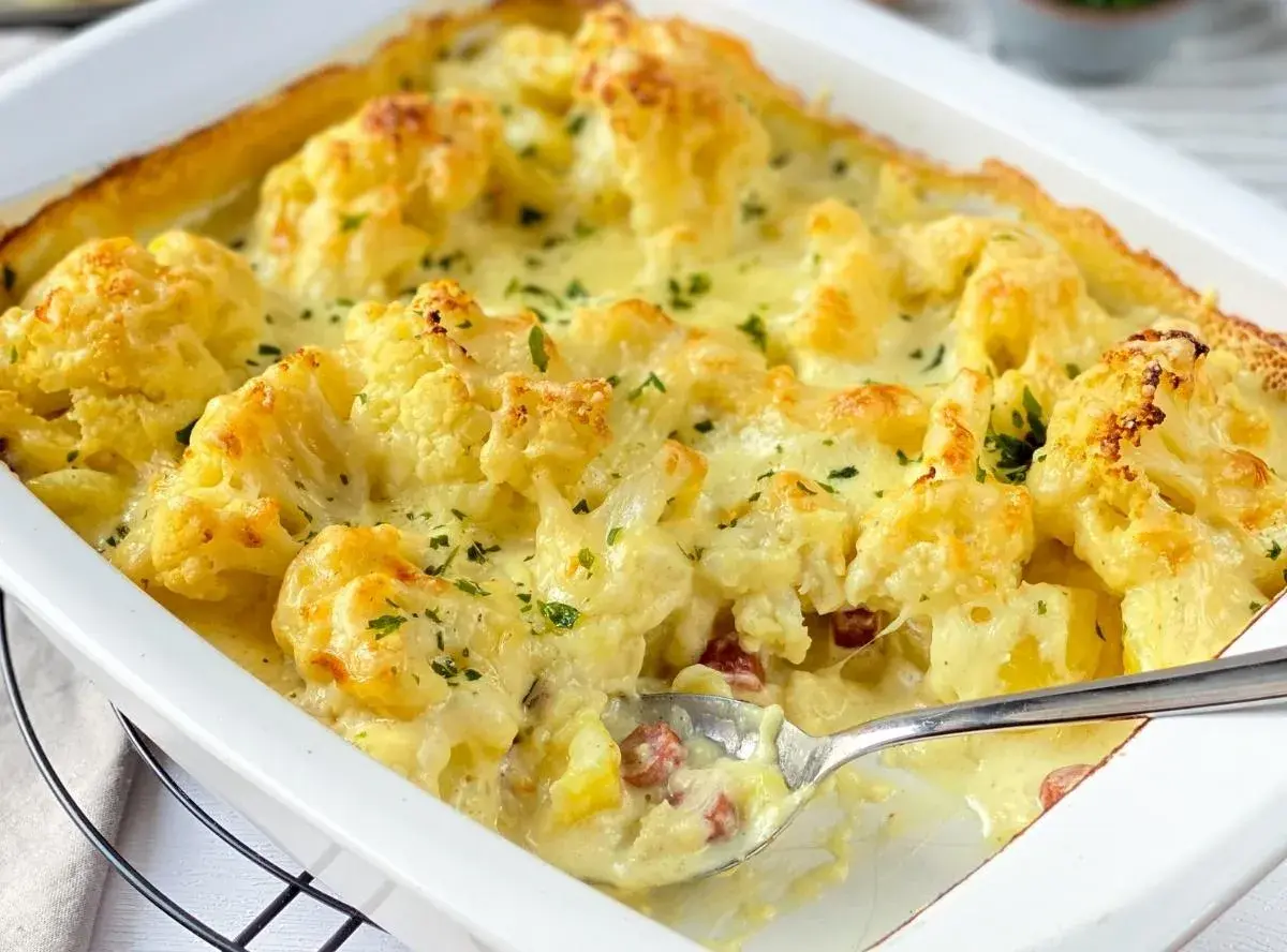 Ein cremiger Blumenkohl Kartoffel Auflauf mit Käse überbacken, garniert mit Petersilie. Perfekt für ein herzhaftes Abendessen.