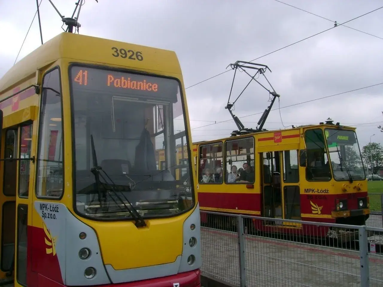 Dwa żółto-czerwone tramwaje MPK Łódź, jeden z napisem "41 Pabianice", stoją na torach.