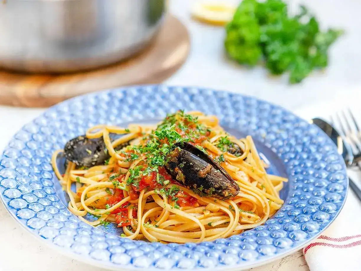 En tallrik med spaghetti allo scoglio, toppad med färska örter och musslor. En härlig italiensk pastarätt.