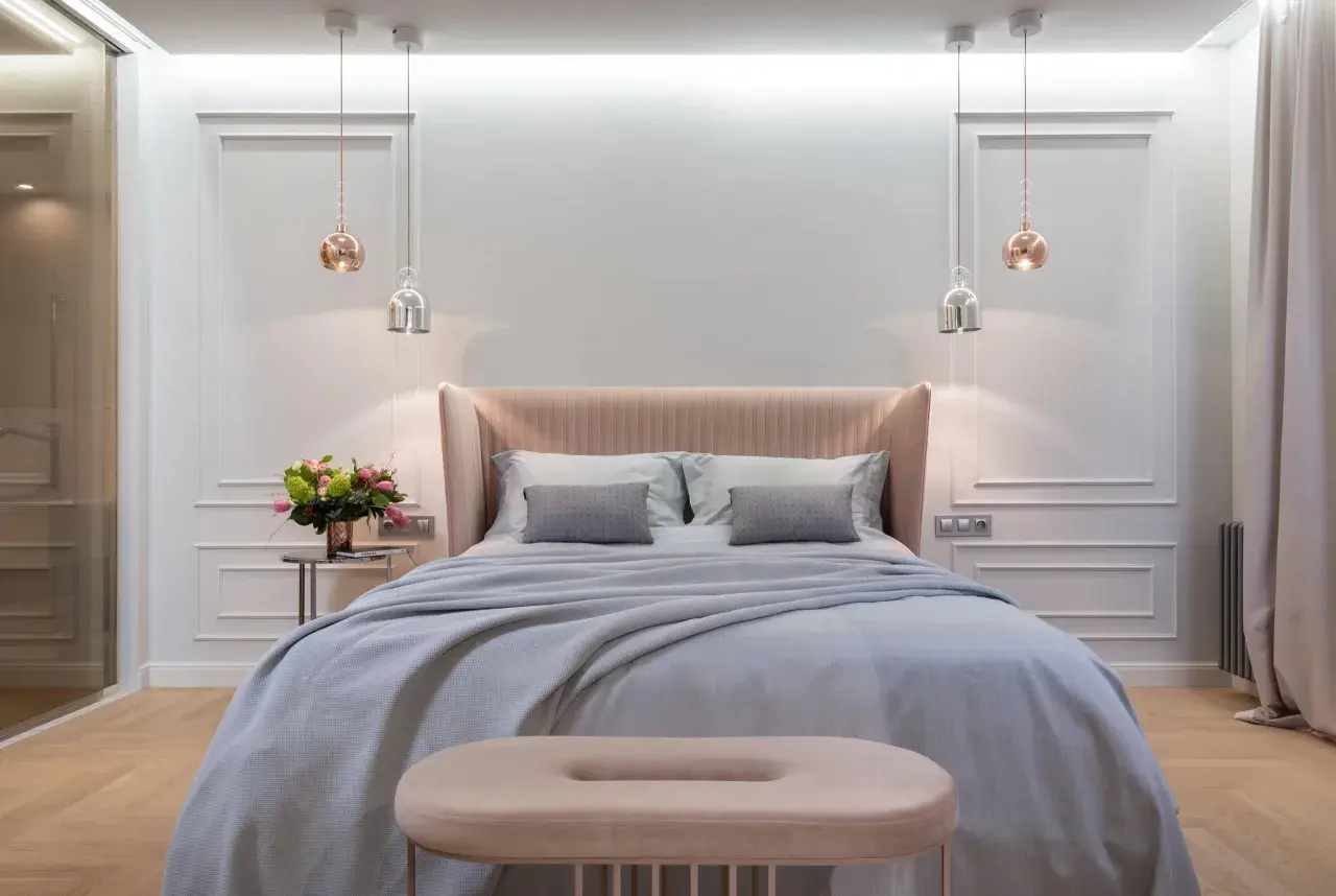 Achieve that hotel bed at home feeling with this plush, inviting bedroom setup. Soft linens, a cozy throw, and elegant lighting create a serene sanctuary.