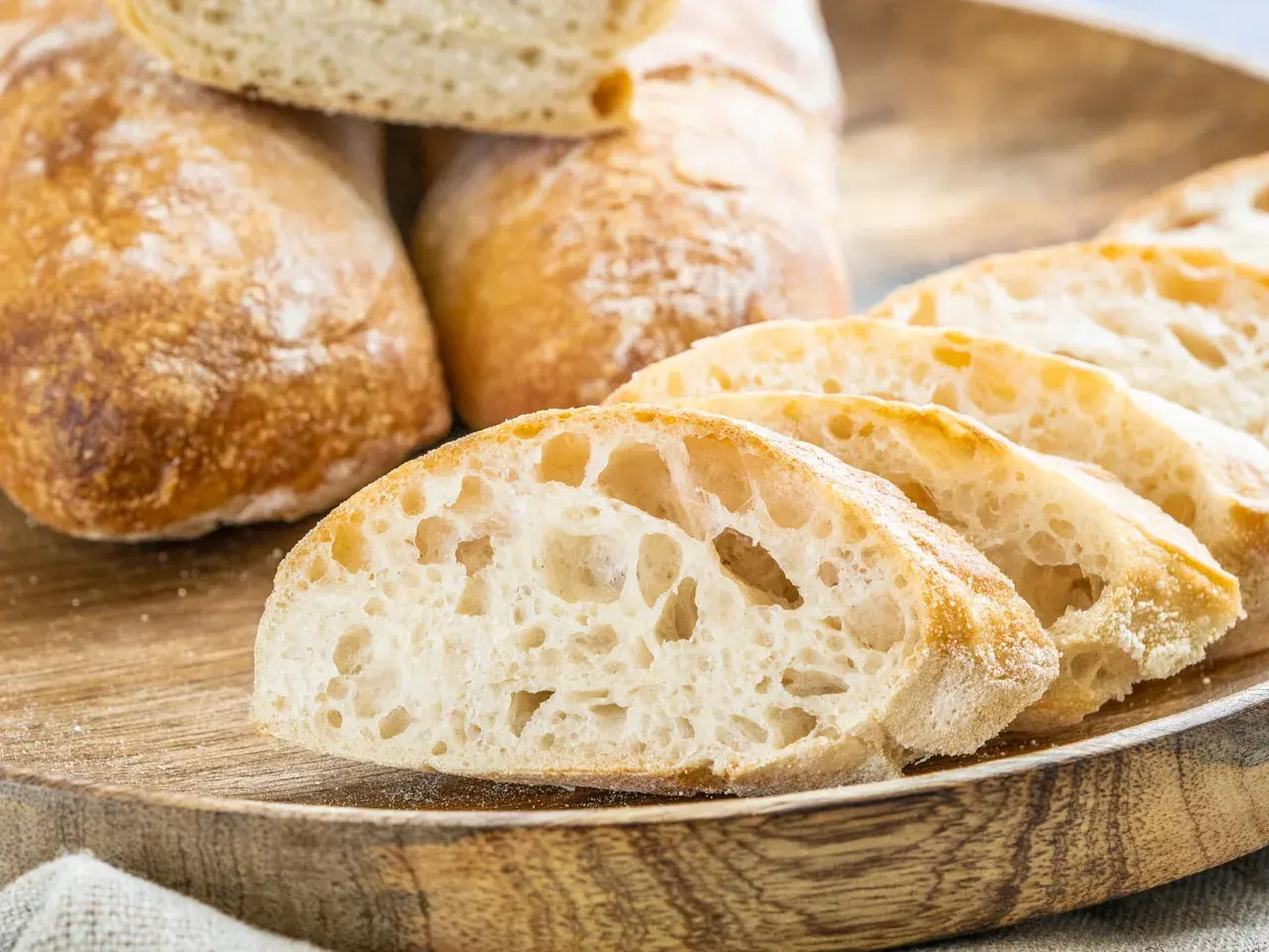 Frisch gebackene Ciabatta-Brote, aufgeschnitten auf einem Holzbrett. Dieses Ciabatta Rezept ergibt luftiges Brot mit knuspriger Kruste.