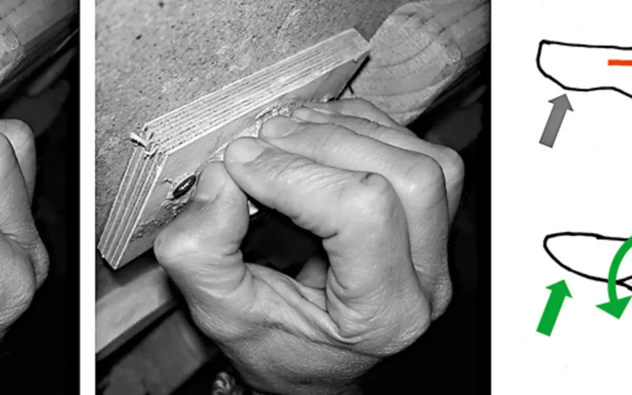 Hand greift Holzleiste, die Finger sind stark gekrümmt. Mögliche Ursache für ringband finger schmerzen.