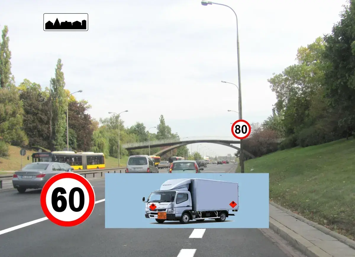 Na drodze widać znak w21 informujący o końcu obszaru zabudowanego. Obok znak ograniczenia prędkości do 60 km/h. W tle jadą samochody i autobusy.