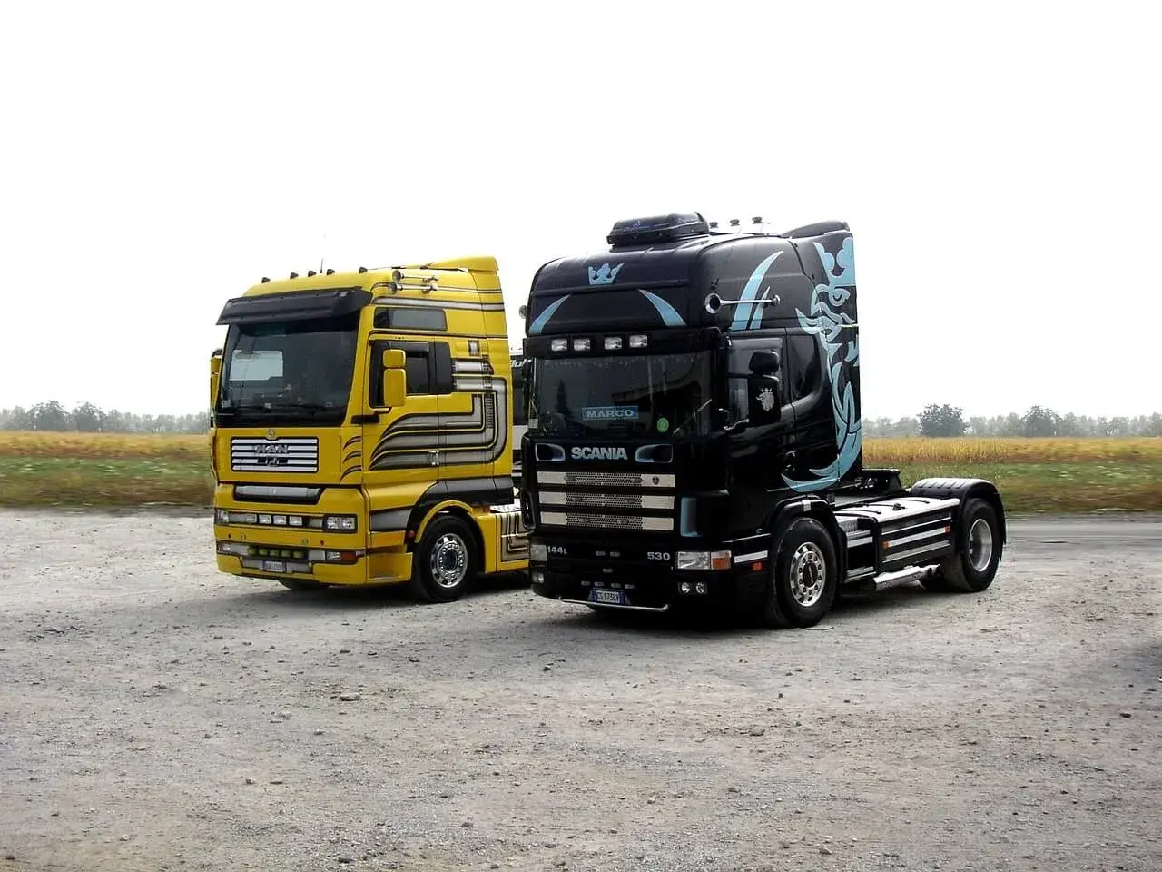 Dwa potężne ciągniki siodłowe: żółty MAN i czarna Scania. Zastanawiasz się, ile waży ciężarówka bez naczepy?