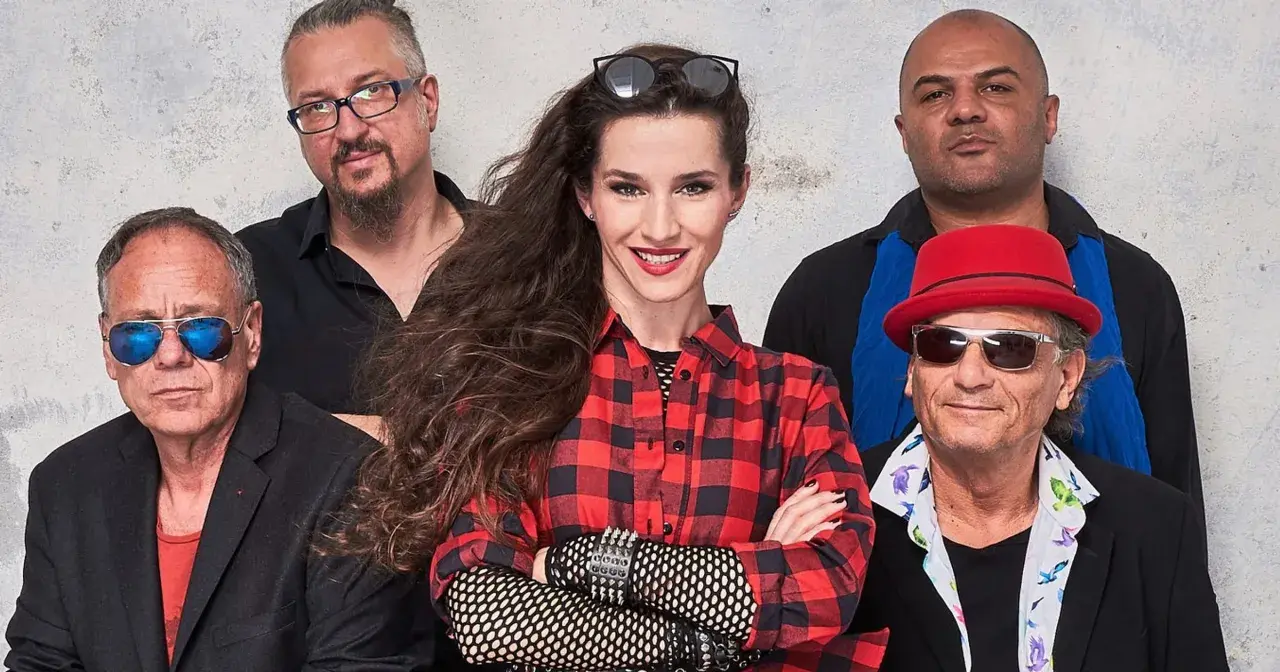 Zespół Maanam w nowym składzie: wokalistka w kratę, gitarzysta w czerwonym kapeluszu i reszta ekipy gotowa na scenę.
