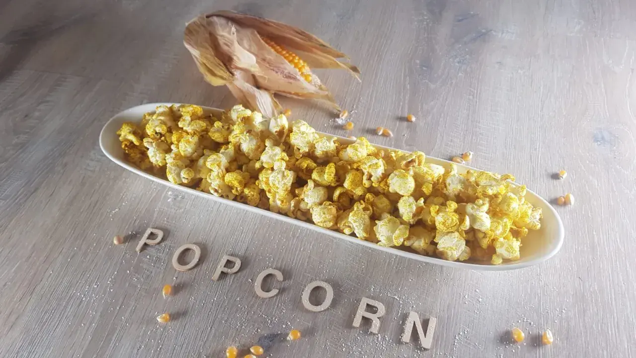 Leckeres Popcorn in einer Schale, daneben ein Maiskolben. Informiere dich über die Mais Nährwerte für einen gesunden Snack.