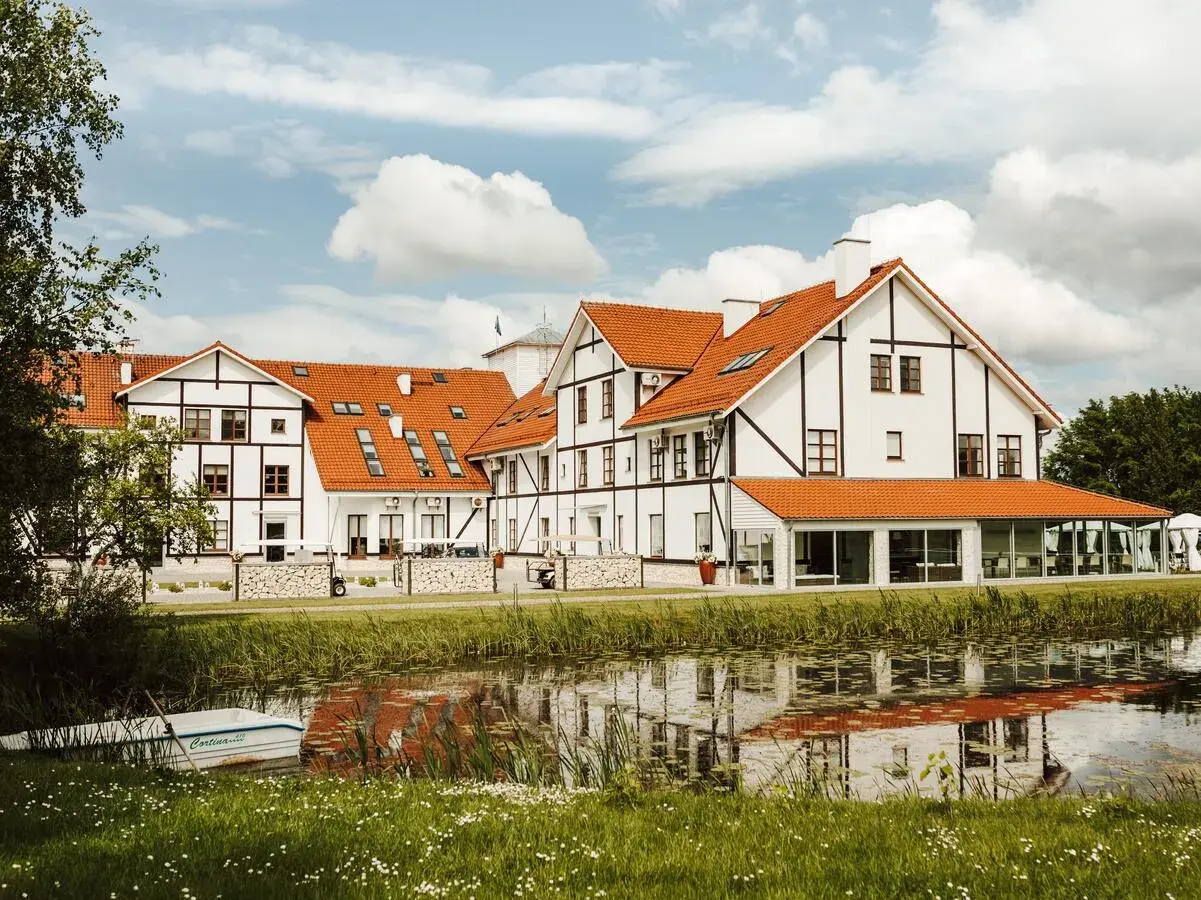 Malowniczy widok na narie resort & spa z łódką przy brzegu i odbiciem w wodzie.