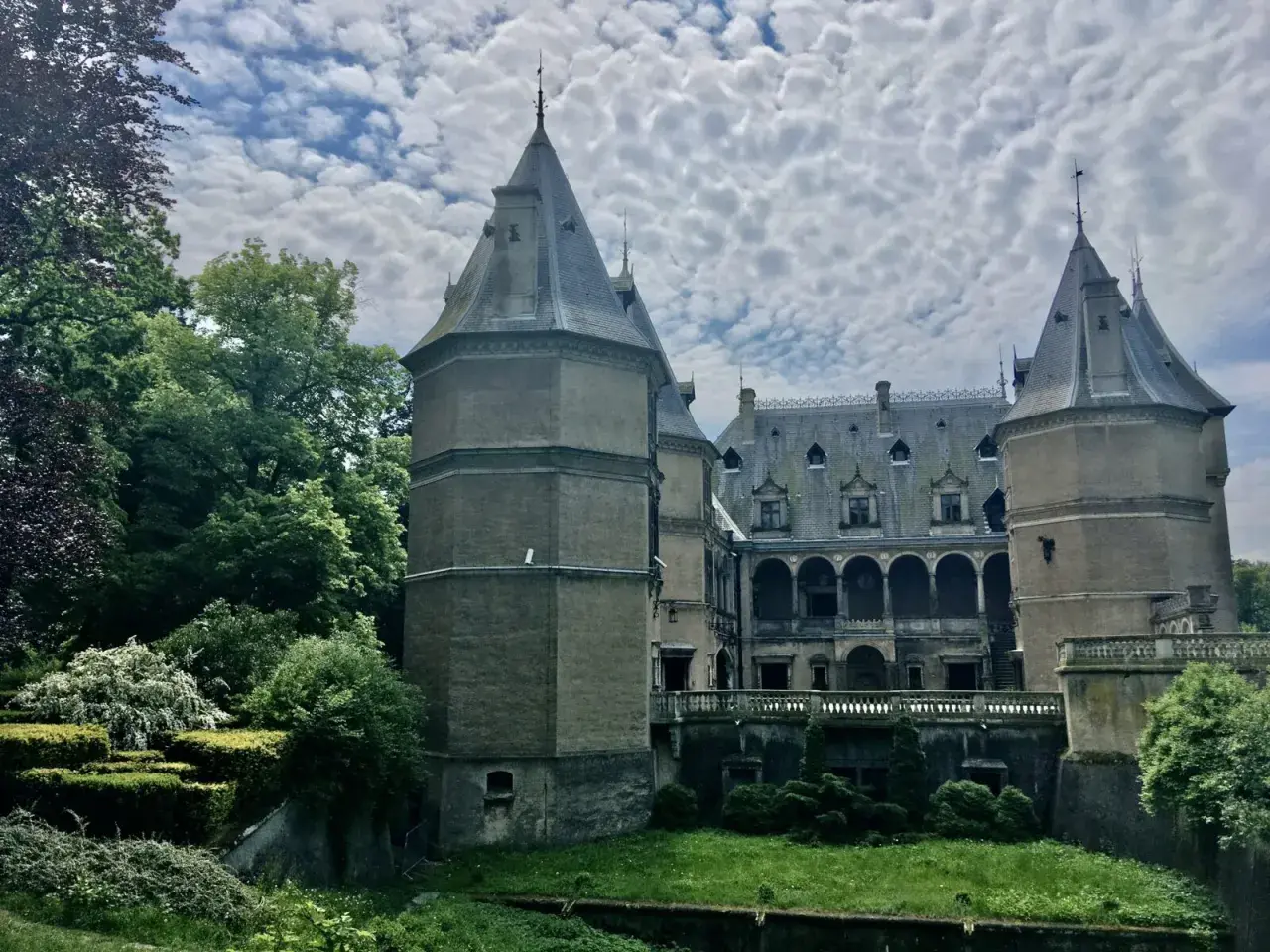 Zamek w Gołuchowie, otoczony zielenią, z wieżami i arkadowym dziedzińcem. Ciekawostki o jego historii i architekturze zachwycają.