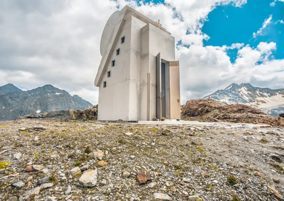 Moderne Kapelle am Pitztaler Gletscher, umgeben von felsiger Landschaft und schneebedeckten Bergen.