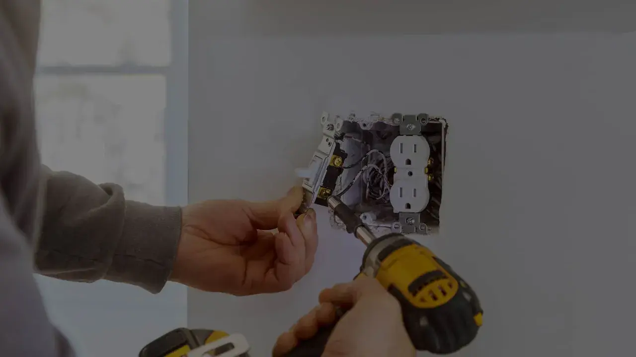 Elektryk montuje gniazdko i włącznik. Zastanawiasz się, ile kosztuje godzina pracy elektryka?