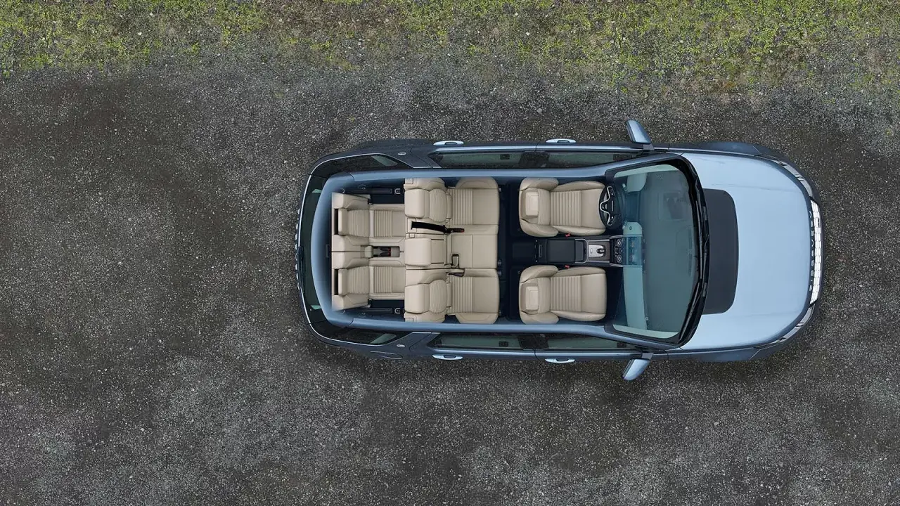 Widok z góry na wnętrze Land Rover Discovery z jasnymi, skórzanymi siedzeniami, gotowe na rodzinną podróż.