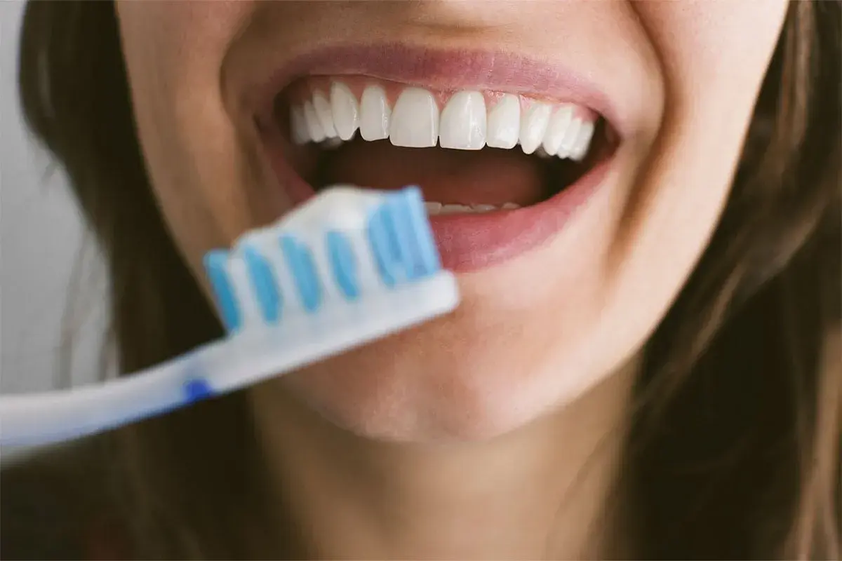 Sorriso smagliante con denti bianchi e spazzolino. Dedicare 10 minuti a lavarsi i denti garantisce un sorriso sano e luminoso.