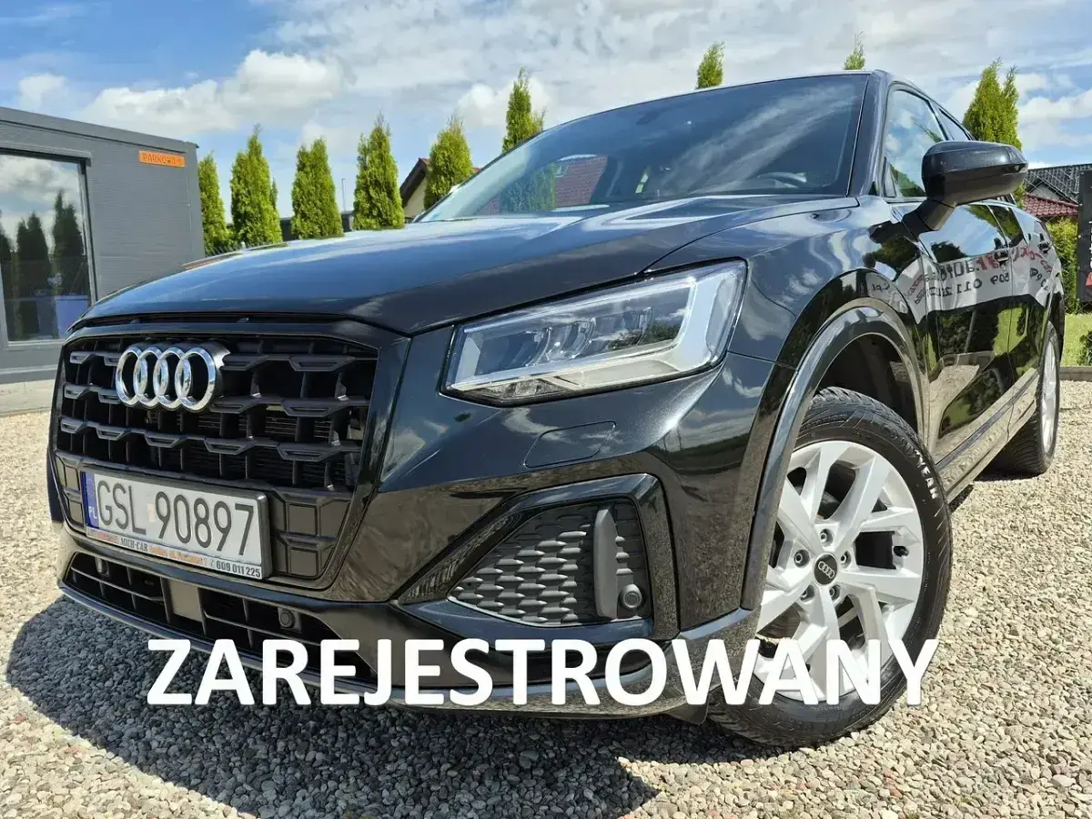 Czarny Audi Q2 na żwirowym podjeździe. Sprawdź atrakcyjną audi q2 cena i zarezerwuj jazdę próbną.